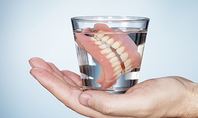 Dentures stored in glass of water