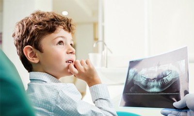 young dental patient looking at X-ray 