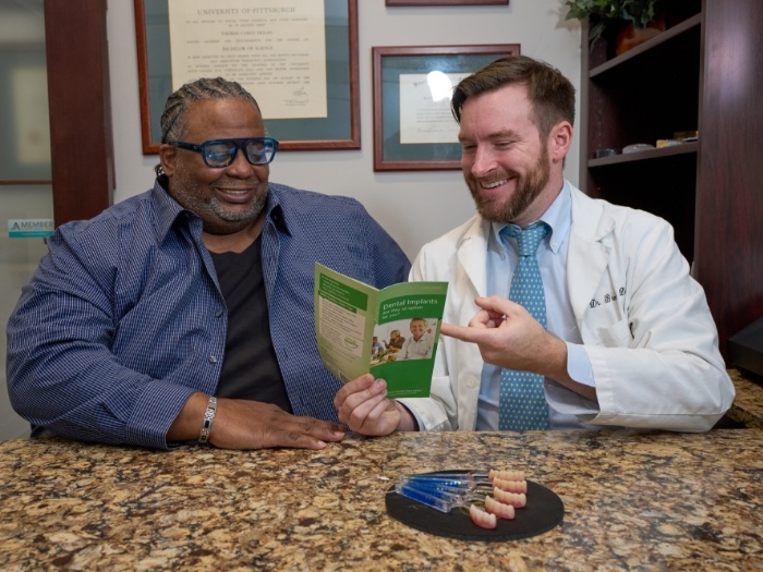Dentist showing dental patient a brochure
