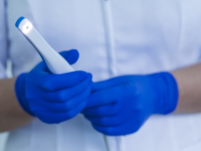 Gloved hands holding an intraoral camera