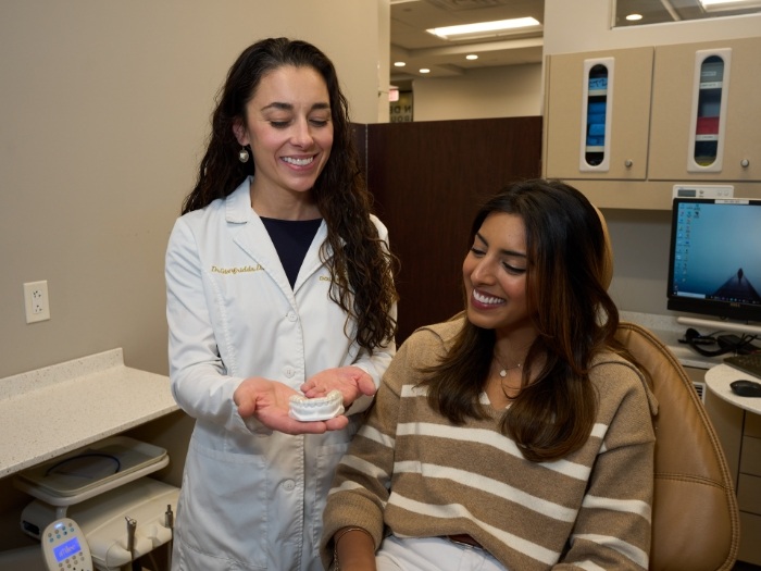 Dentist showing patient model of teeth