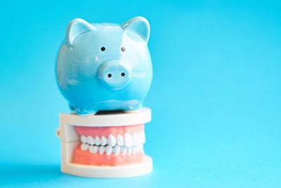 light blue piggy bank sitting on top of a set of dentures in Wethersfield 