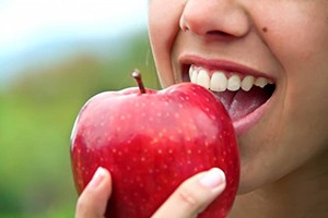 close-up of a person eating a red apple