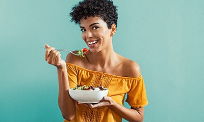 Woman smiling while eating healthy meal