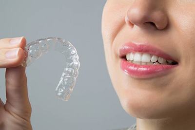 Close-up of woman holding clear aligner