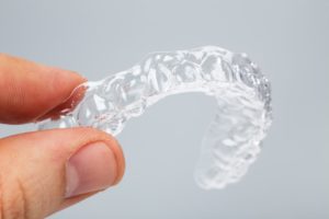 A person holding a clear aligner.