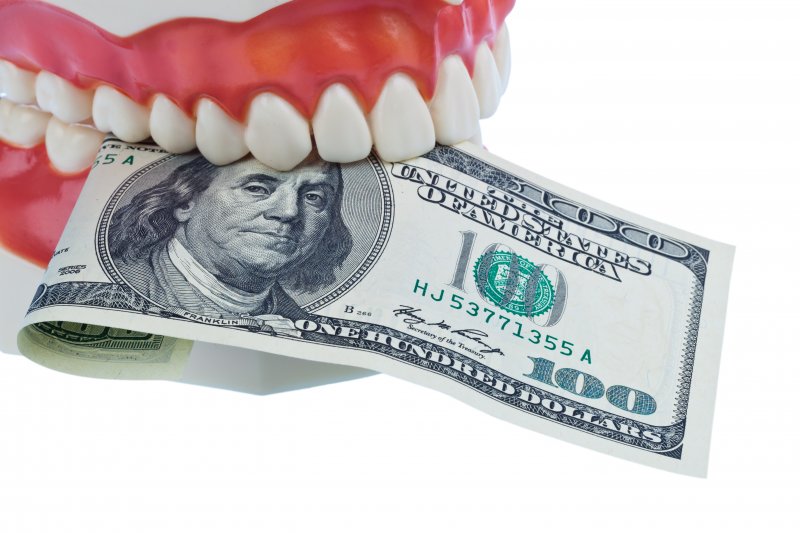 model mouth holding bill in between teeth