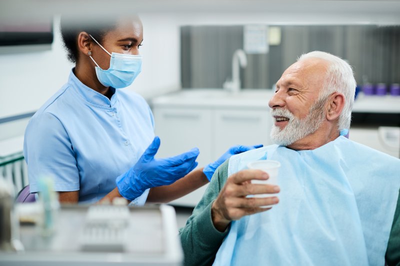 man talking to dentist about getting dental implants in Wethersfield