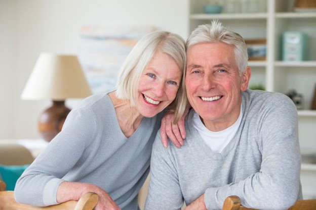 Smiling couple with dental implants.